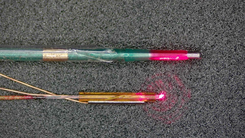 The miniature piezoelectric-driven micro-optical probe (bottom) is shown with a commercial balloon dilatation catheter (top) for size comparison. The probe measures just 0.55 mm in diameter and 4 mm in length.