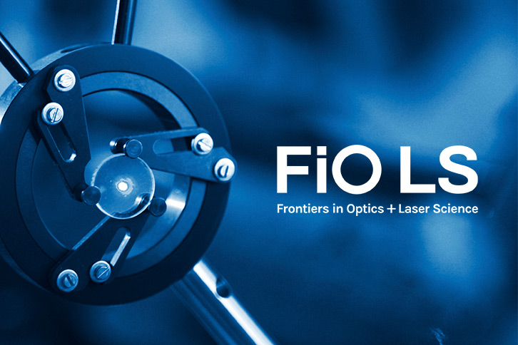 a metal circle brace holding a glass lens on a blue background with the words Frontiers in Optics Laser Science