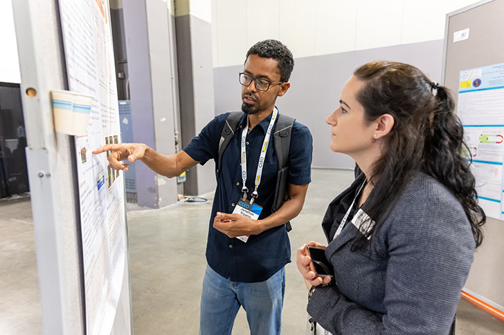 Two people looking at a poster