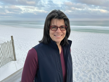 Optica President Gisele Bennett standing on a beach
